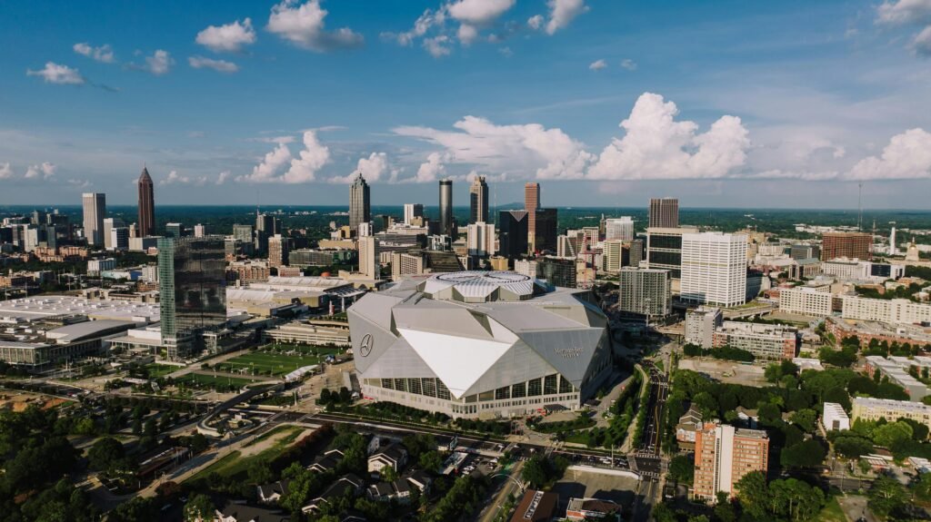 Stunning aerial view of Atlanta skyline featuring the iconic Mercedes-Benz Stadium on a clear day.