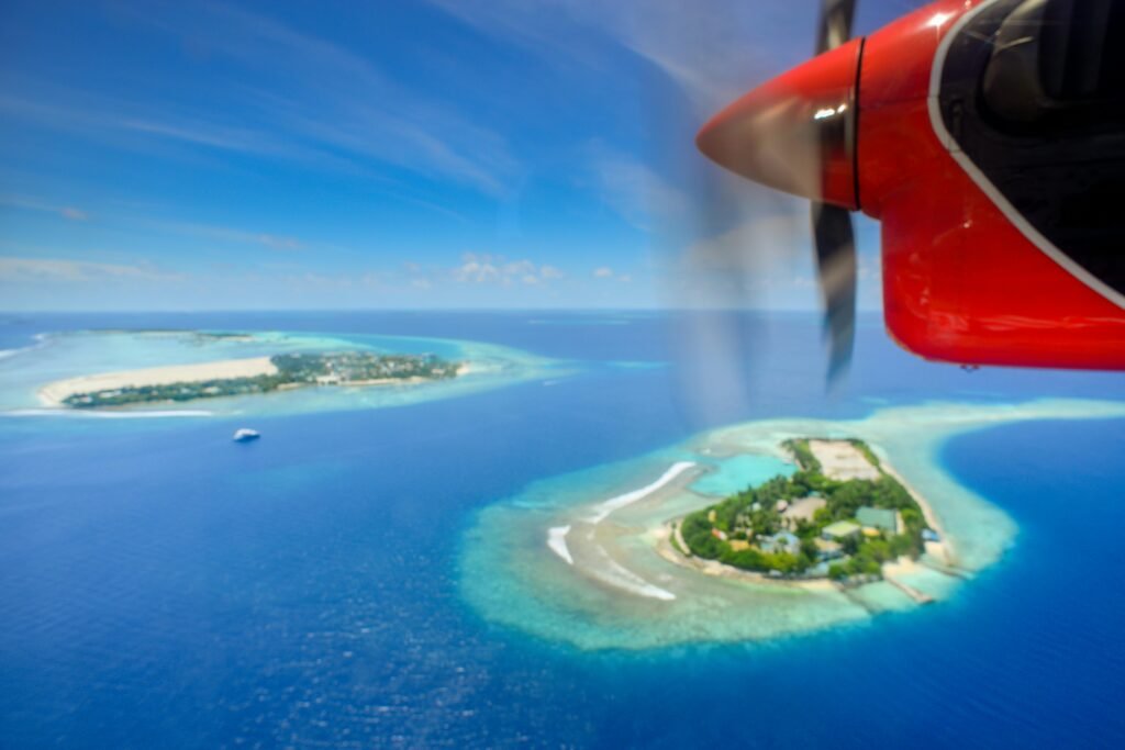 A stunning aerial shot of Maldivian islands captured from a seaplane, showcasing turquoise waters and lush landscapes.