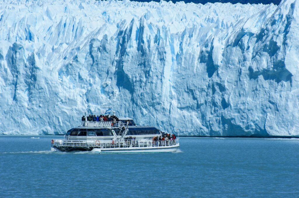 Tourists on a cruise boat explore the majestic Perito Moreno Glacier in Patagonia, Argentina.